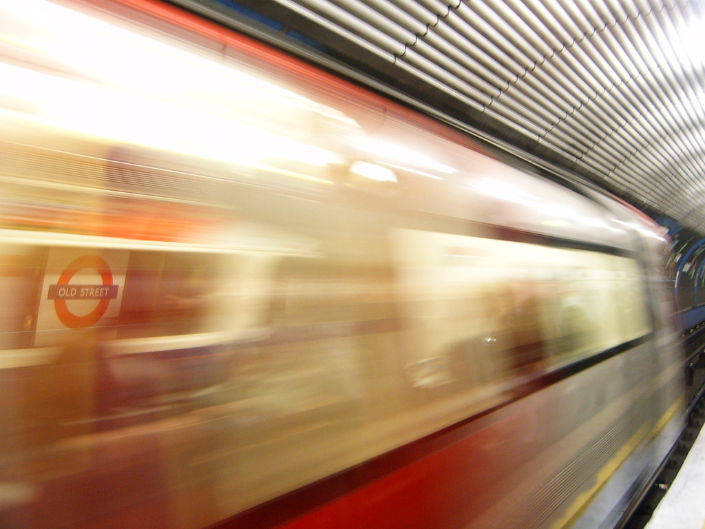 A busy London Underground station platform with a train arriving, illustrating the city's transport network.