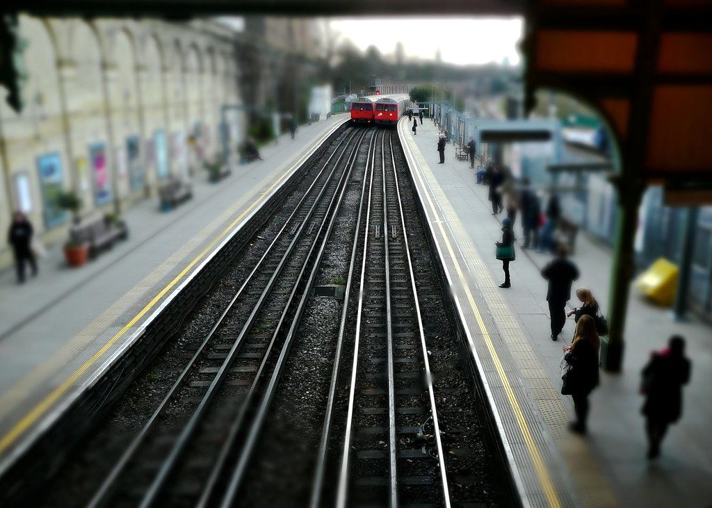 A busy London Underground station with trains arriving and departing, showcasing the scale of TfL's network.