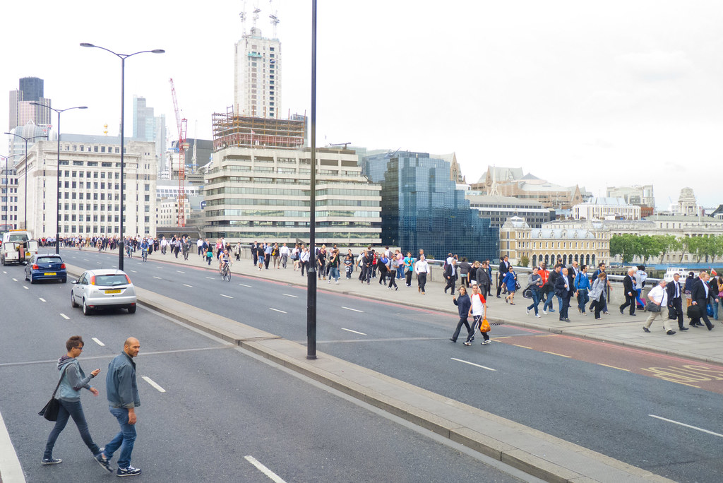 A bustling London Underground station with trains arriving and departing.