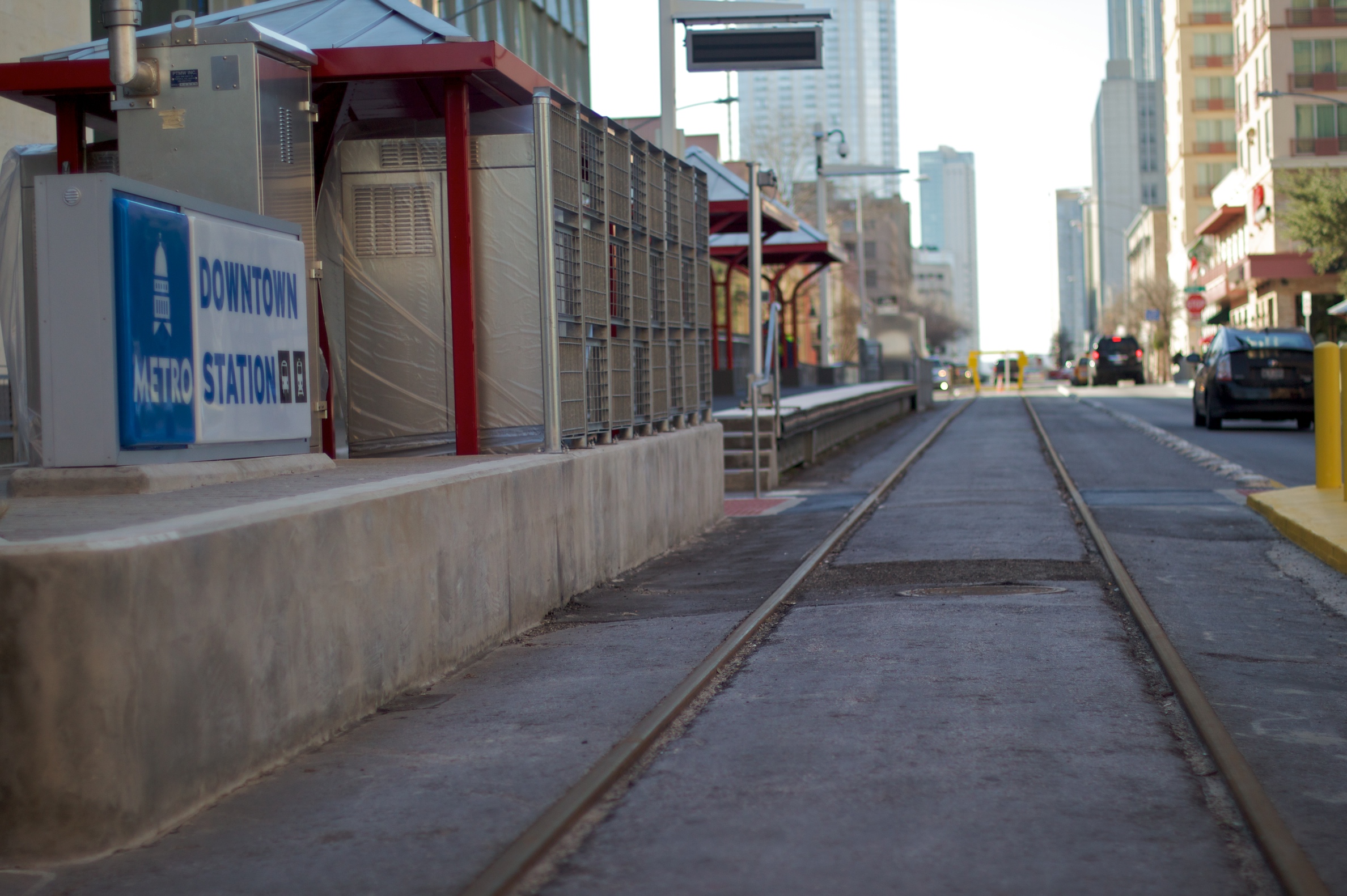A light rail train on tracks in Austin, Texas, under a clear sky.