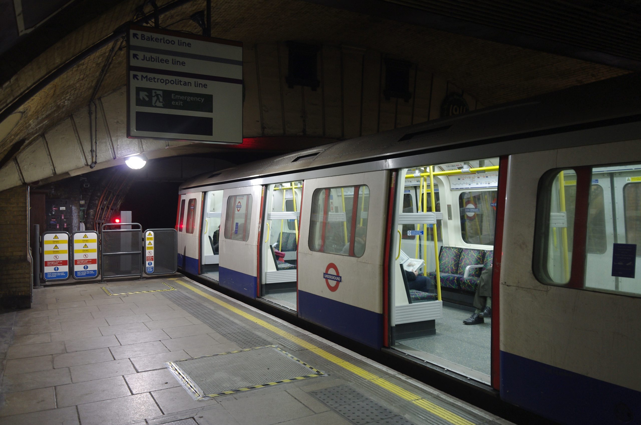 A London Underground train illuminated at night, travelling through a tunnel.