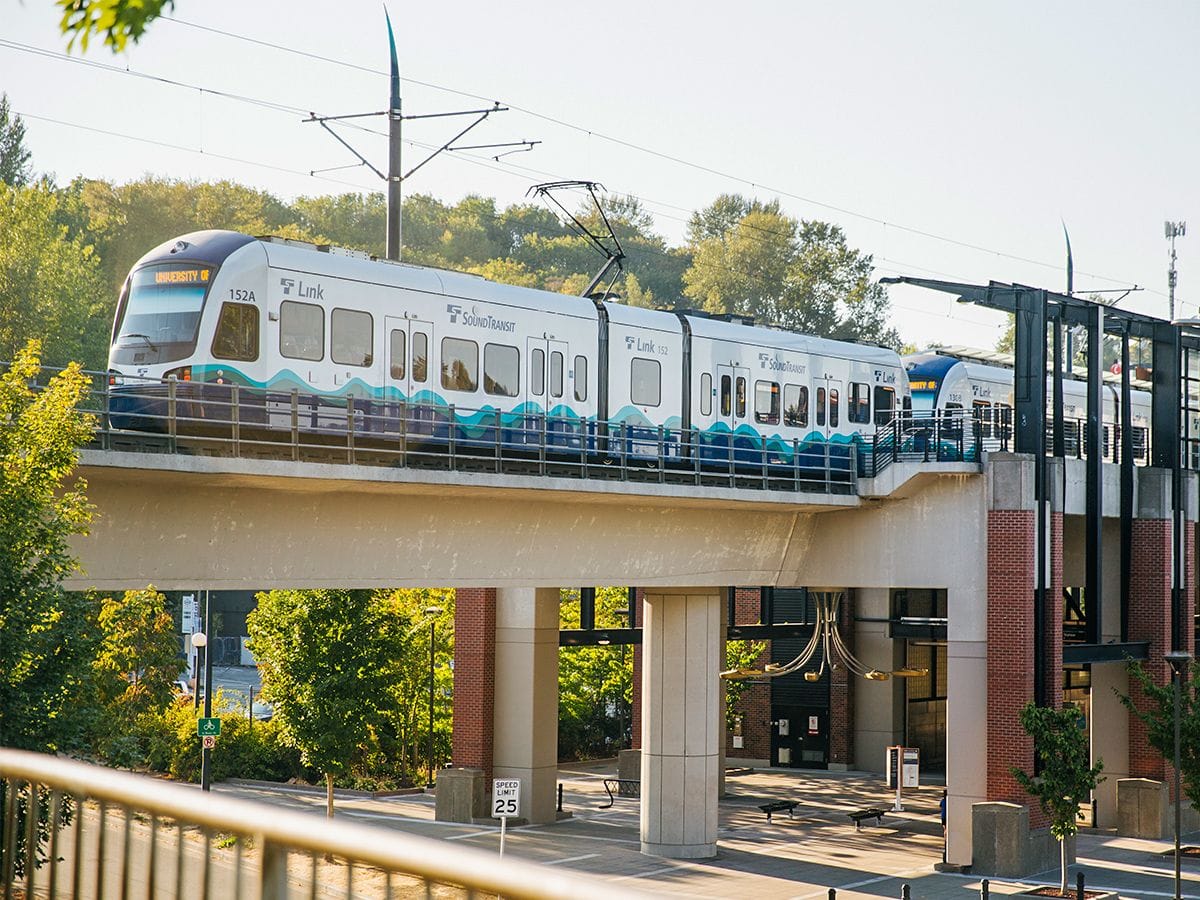 A Sound Transit light rail train operating on elevated tracks in a suburban environment.