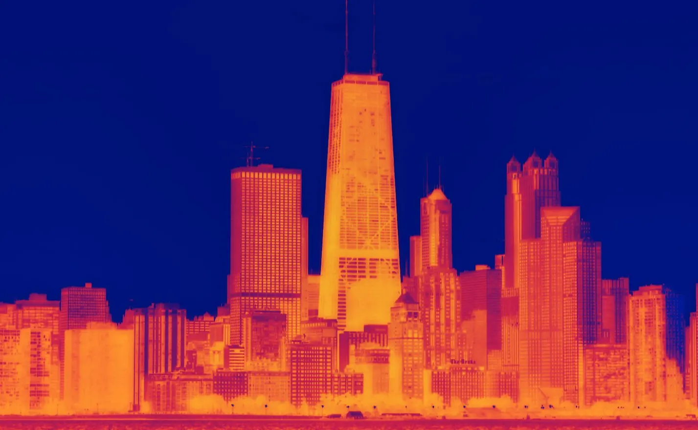 A panoramic view of a city skyline with green spaces and renewable energy infrastructure visible.