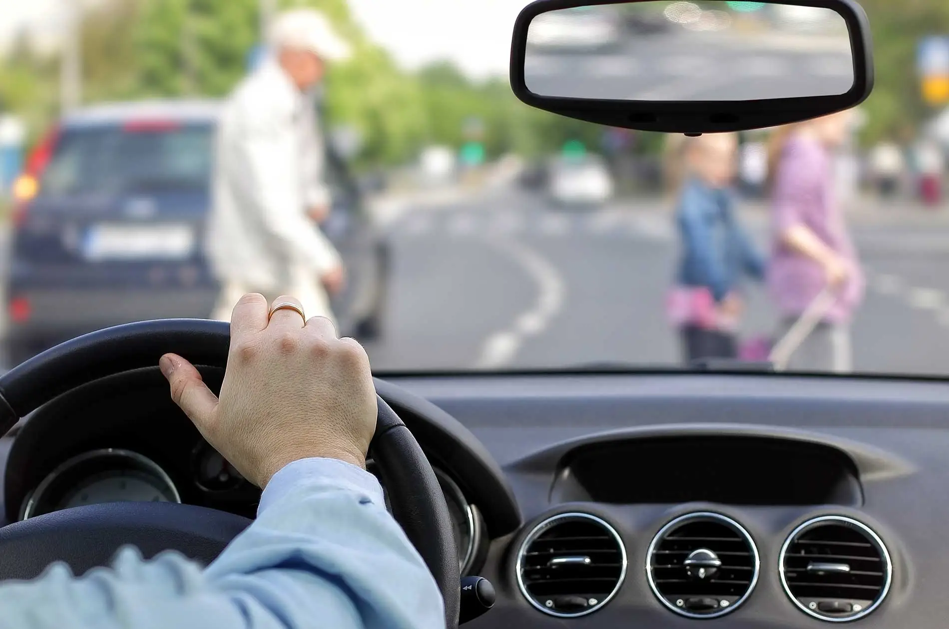 A pedestrian carefully crossing a busy city street at a marked crossing.