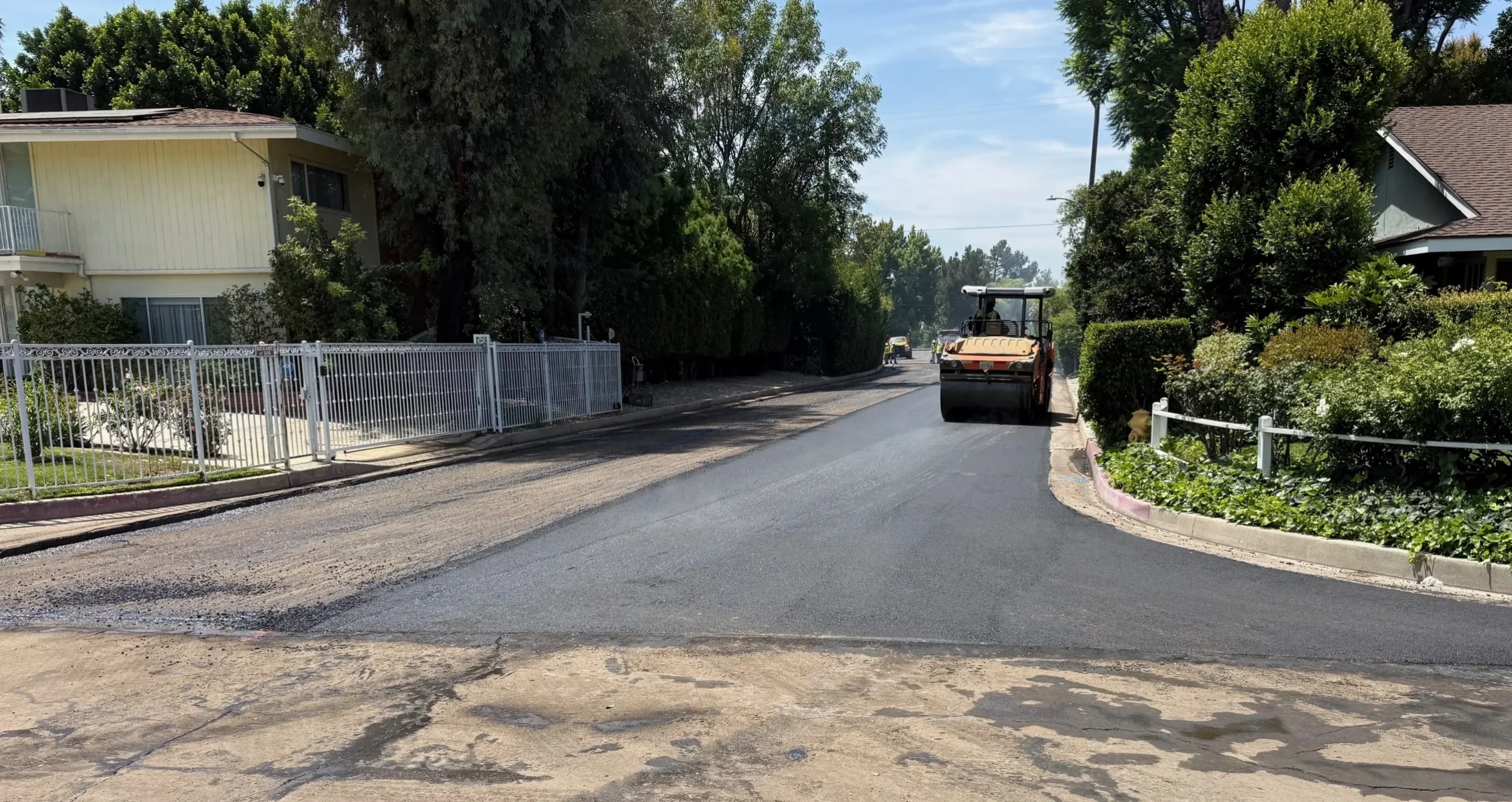 Asphalt paving machinery at work on a residential street in Los Angeles.