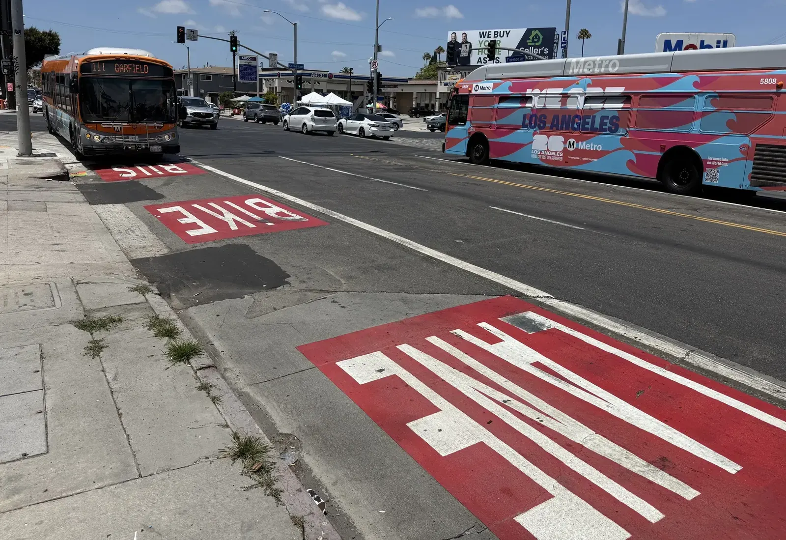 A red-painted bus lane marked on a Los Angeles street.