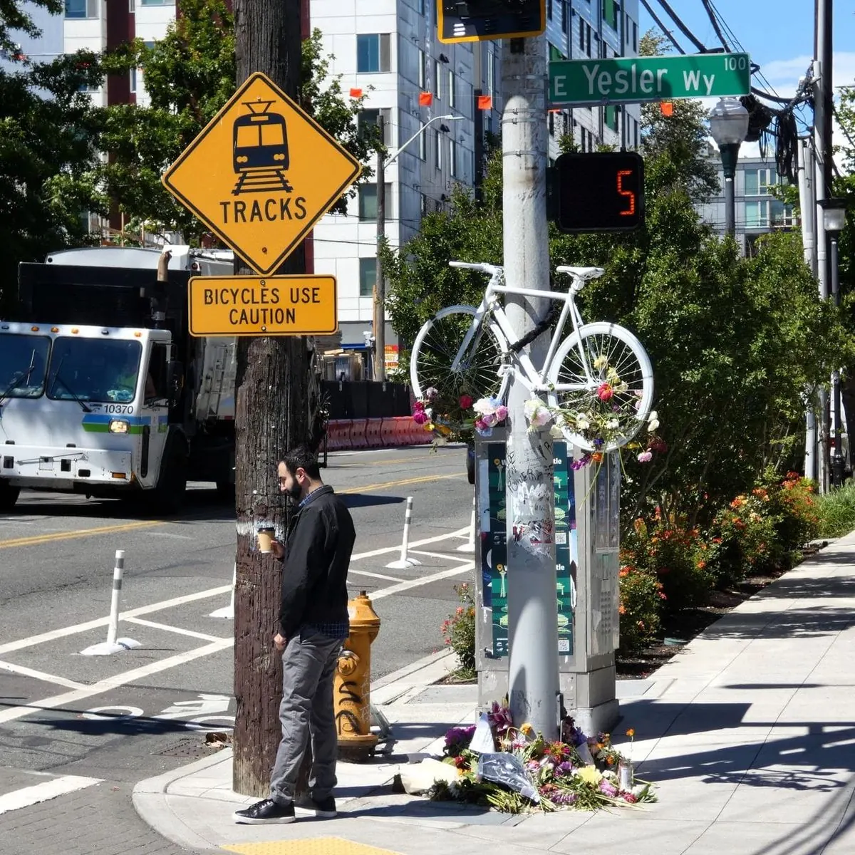 A cyclist rides in a protected bike lane on a Seattle street.
