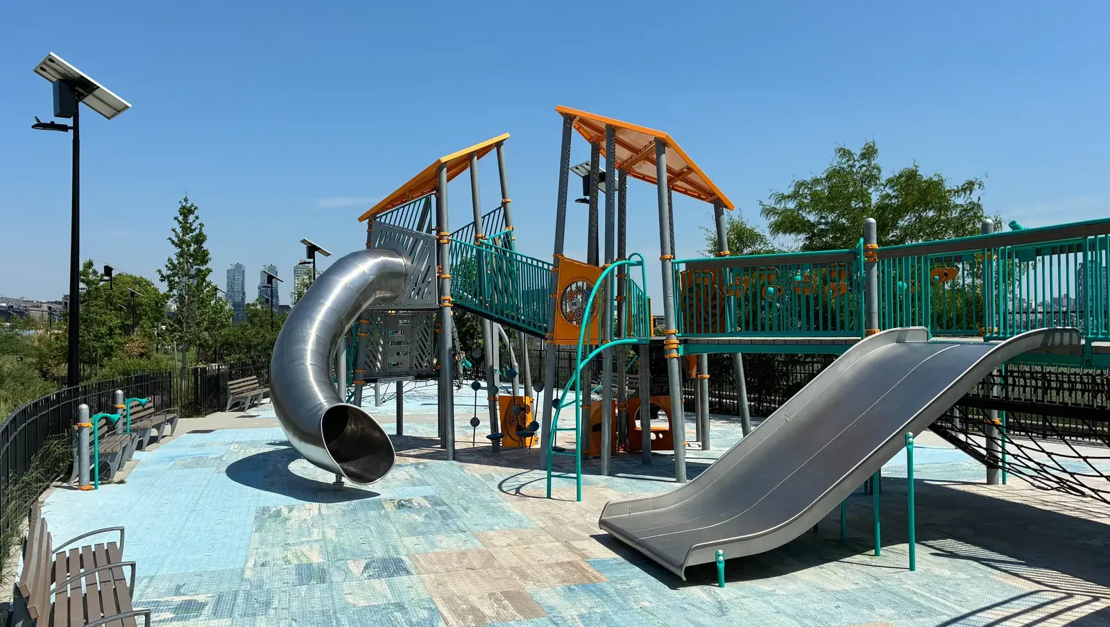 A public playground in London with limited tree cover, exposed to direct sunlight.
