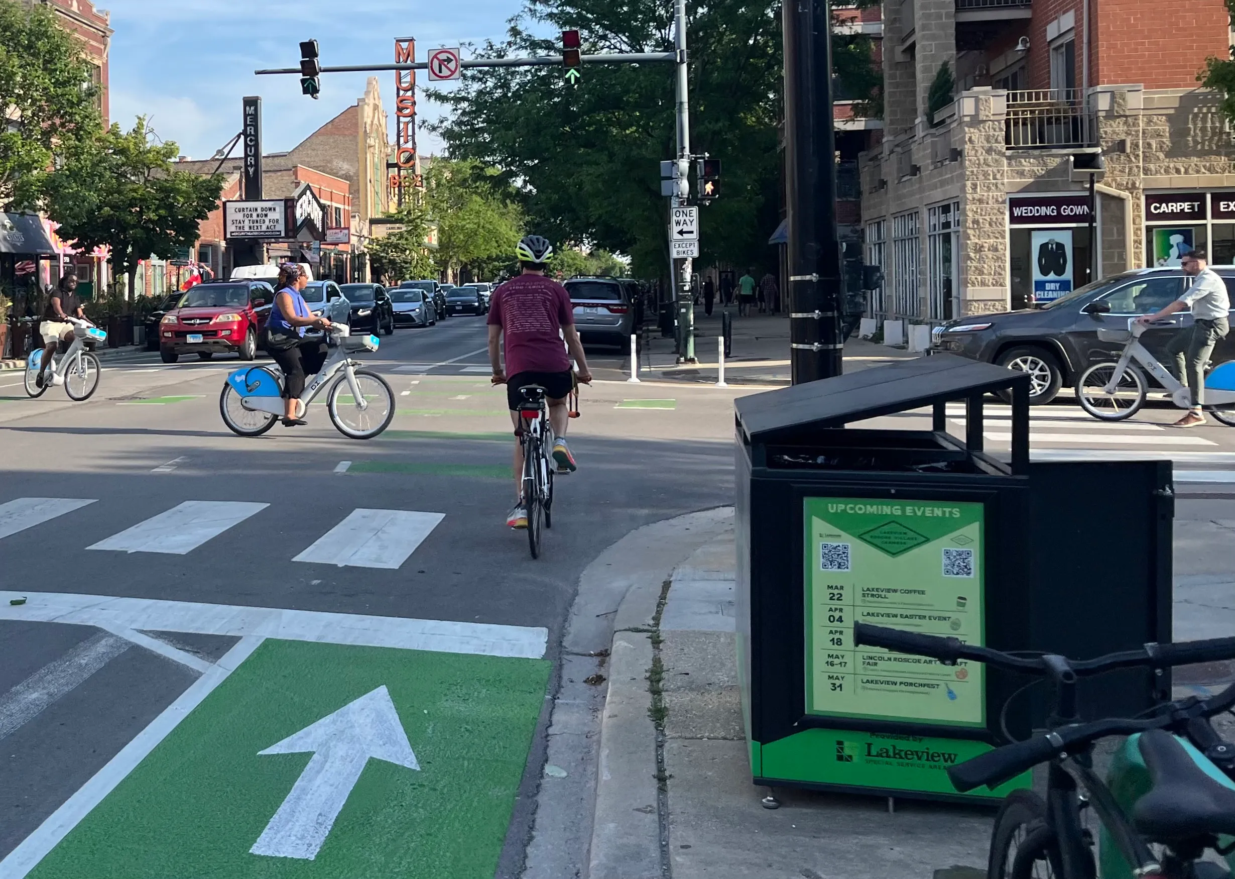 Cyclists using the new Grace Street Neighborhood Greenway in Chicago, with marked lanes and street furniture.