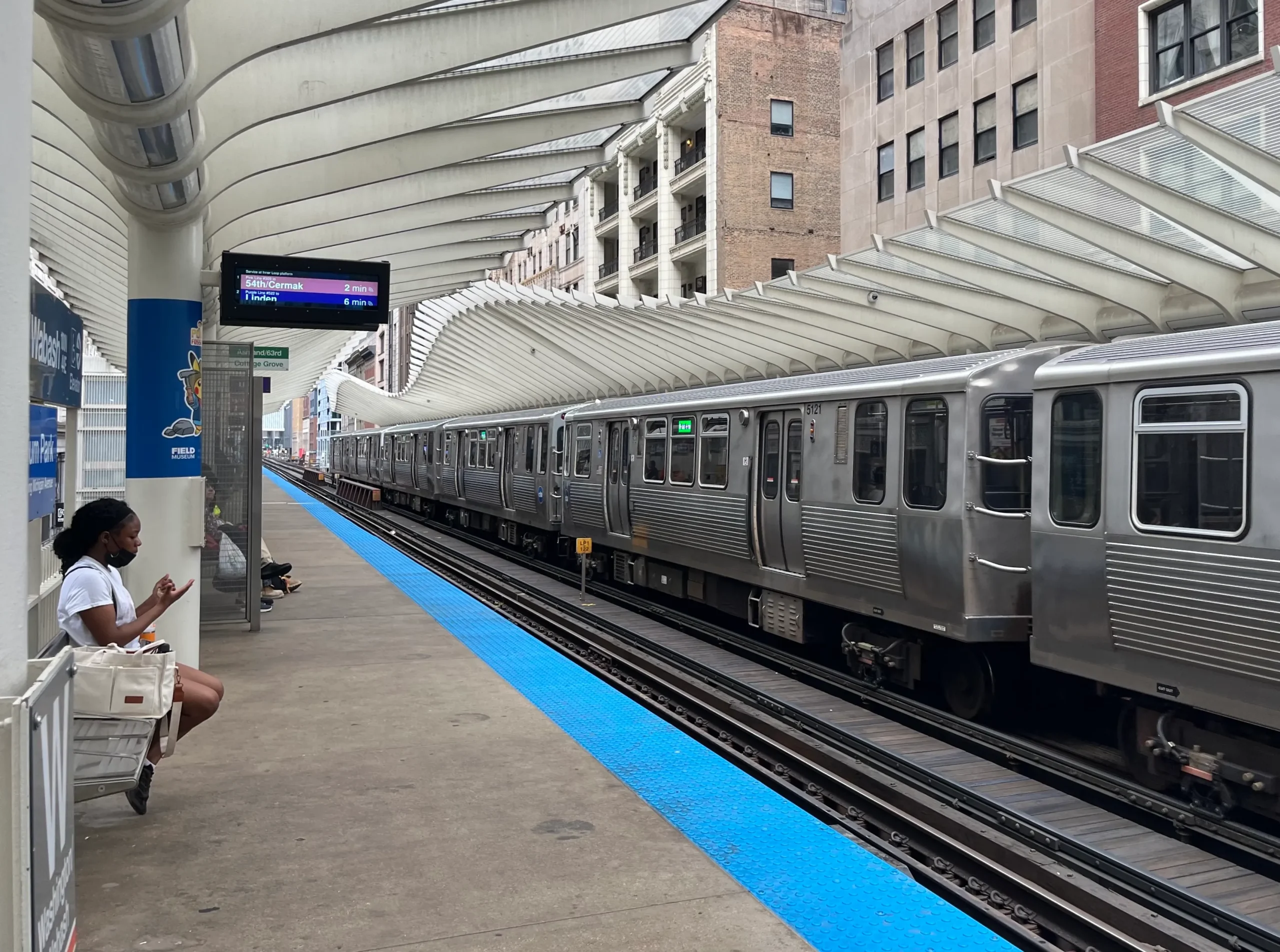 A Chicago Transit Authority Red Line train at an elevated station platform, with passengers visible.