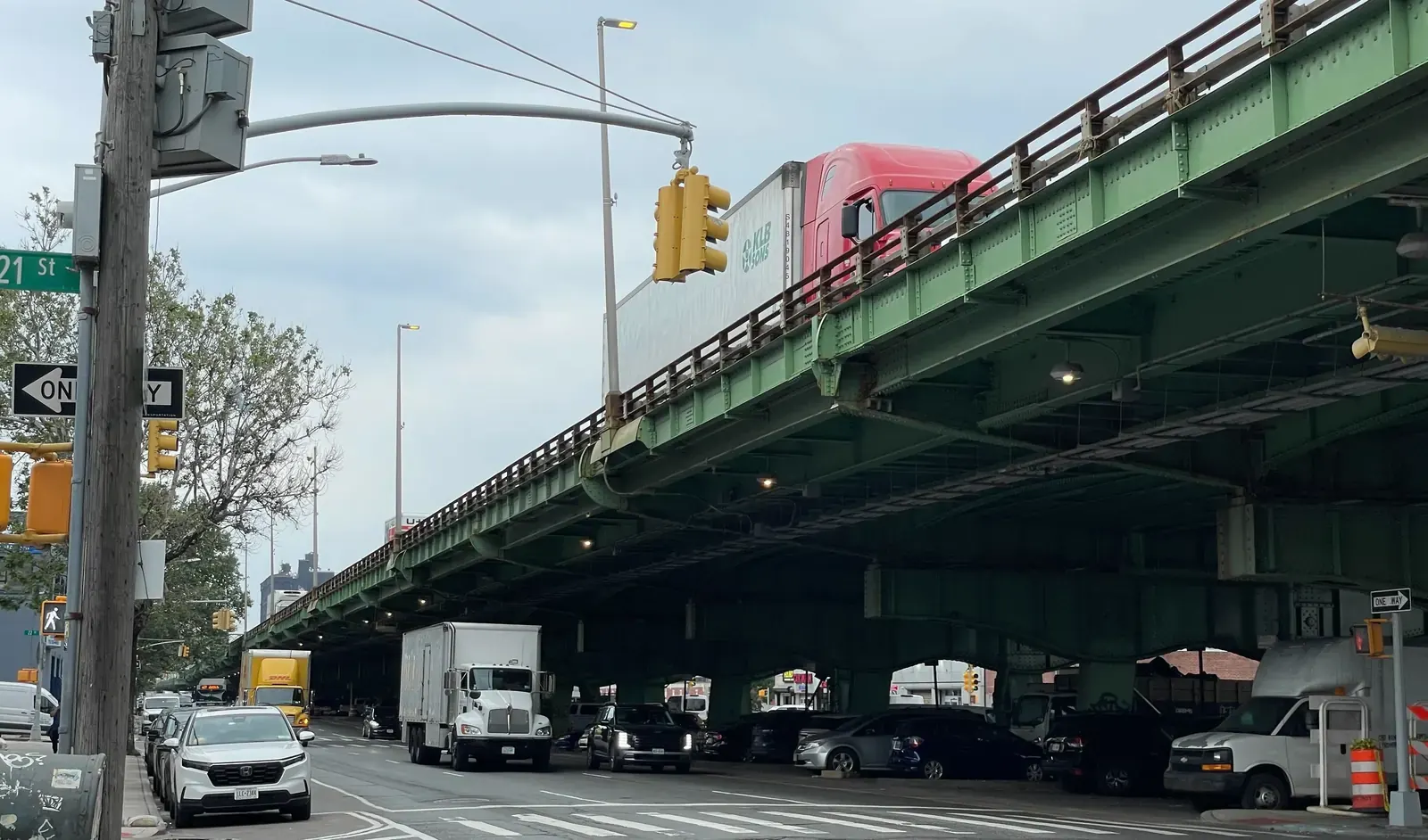 A busy street scene on Third Avenue in Brooklyn, showing vehicle traffic including trucks, pedestrian walkways, and commercial buildings along the corridor.