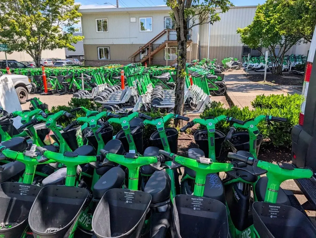 Designated parking corrals for Lime e-scooters and e-bikes near a major sports stadium in Seattle.