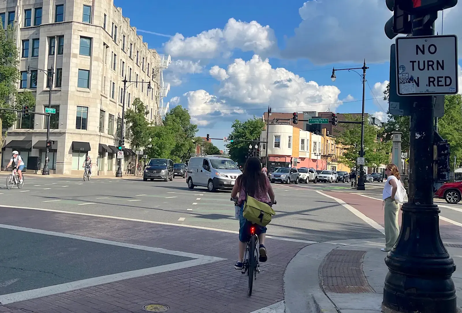 A busy six-way intersection in Chicago with traffic, including cars and cyclists.