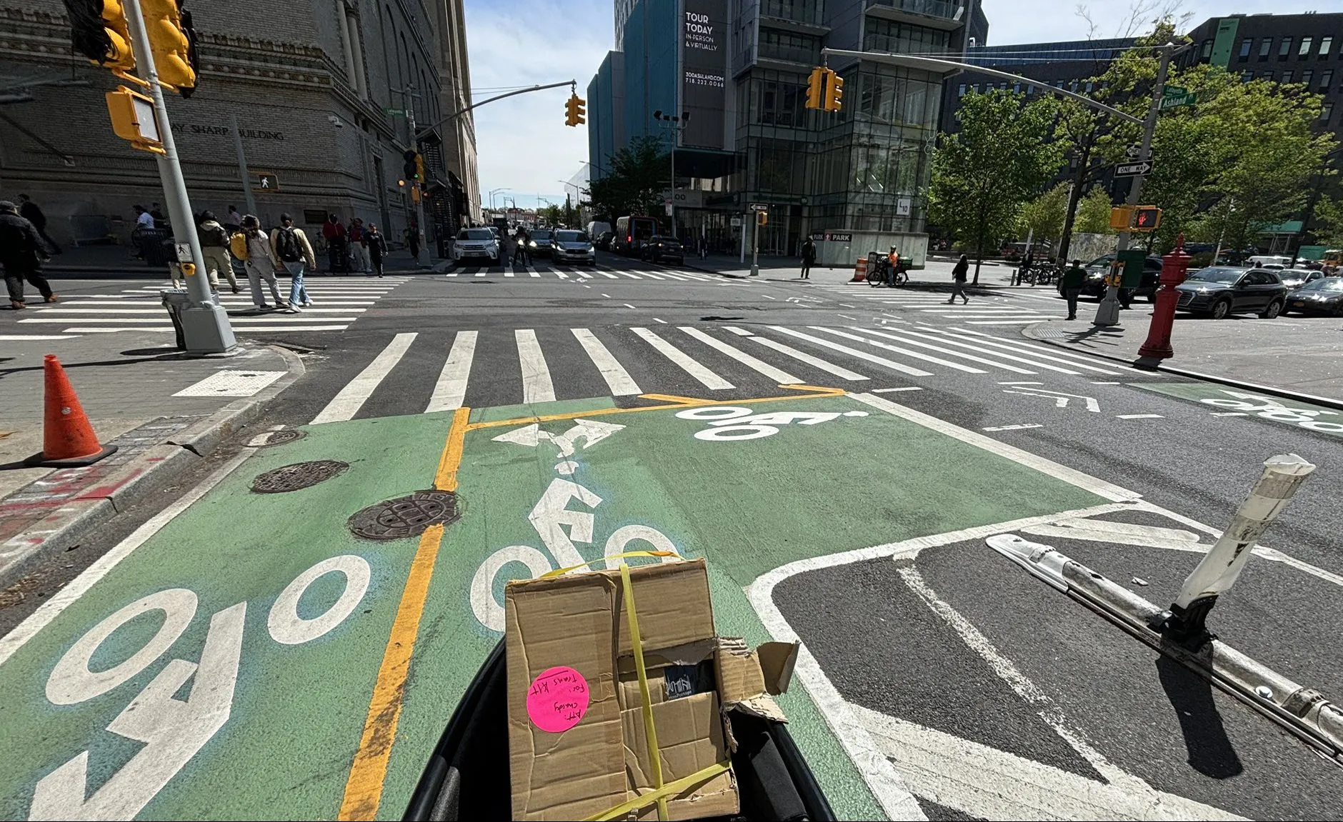 A conceptual rendering or photograph of a protected bike lane on Ashland Place with pedestrian improvements on Hanson Place.