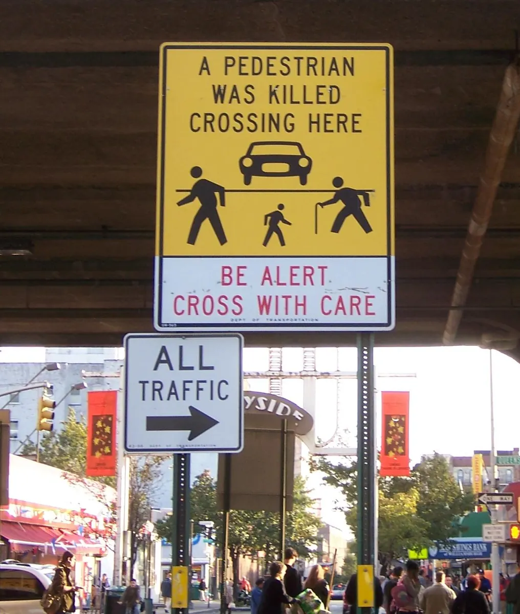 Pedestrians crossing a street in a US city, highlighting safety measures and urban infrastructure.