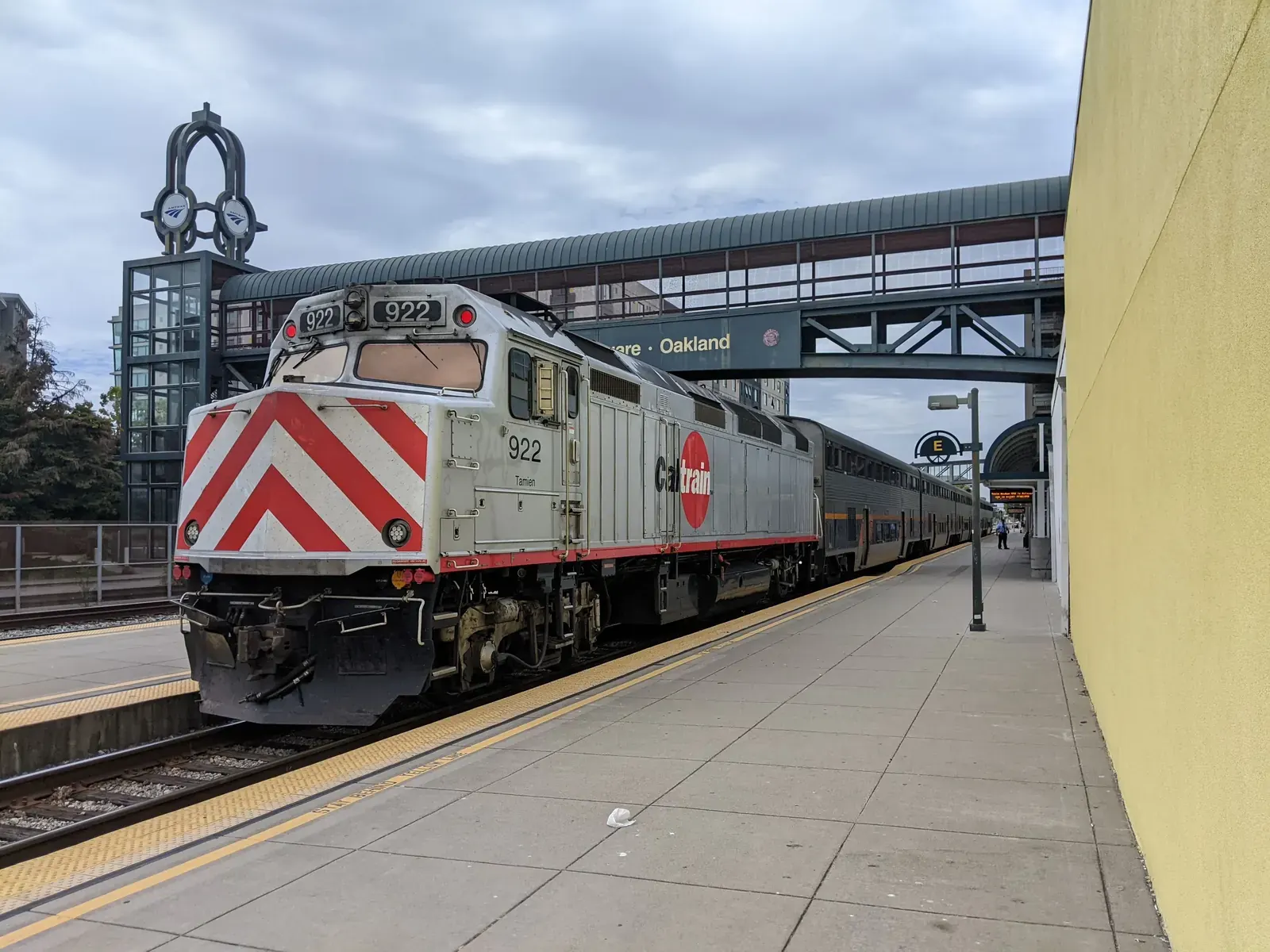 A Caltrain diesel locomotive and passenger coaches at a California rail station