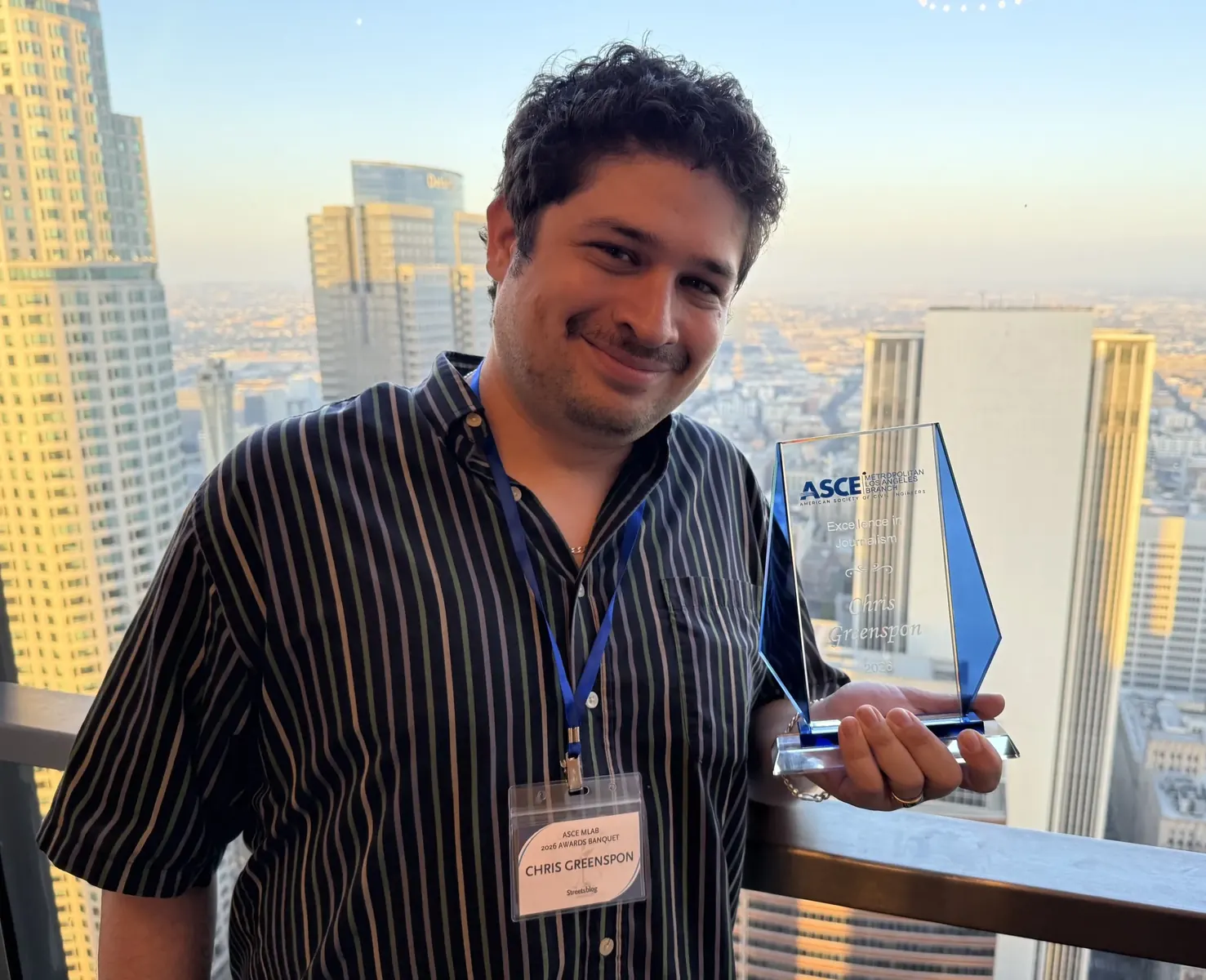 Streetsblog LA reporter Chris Greenspon holding a journalism award