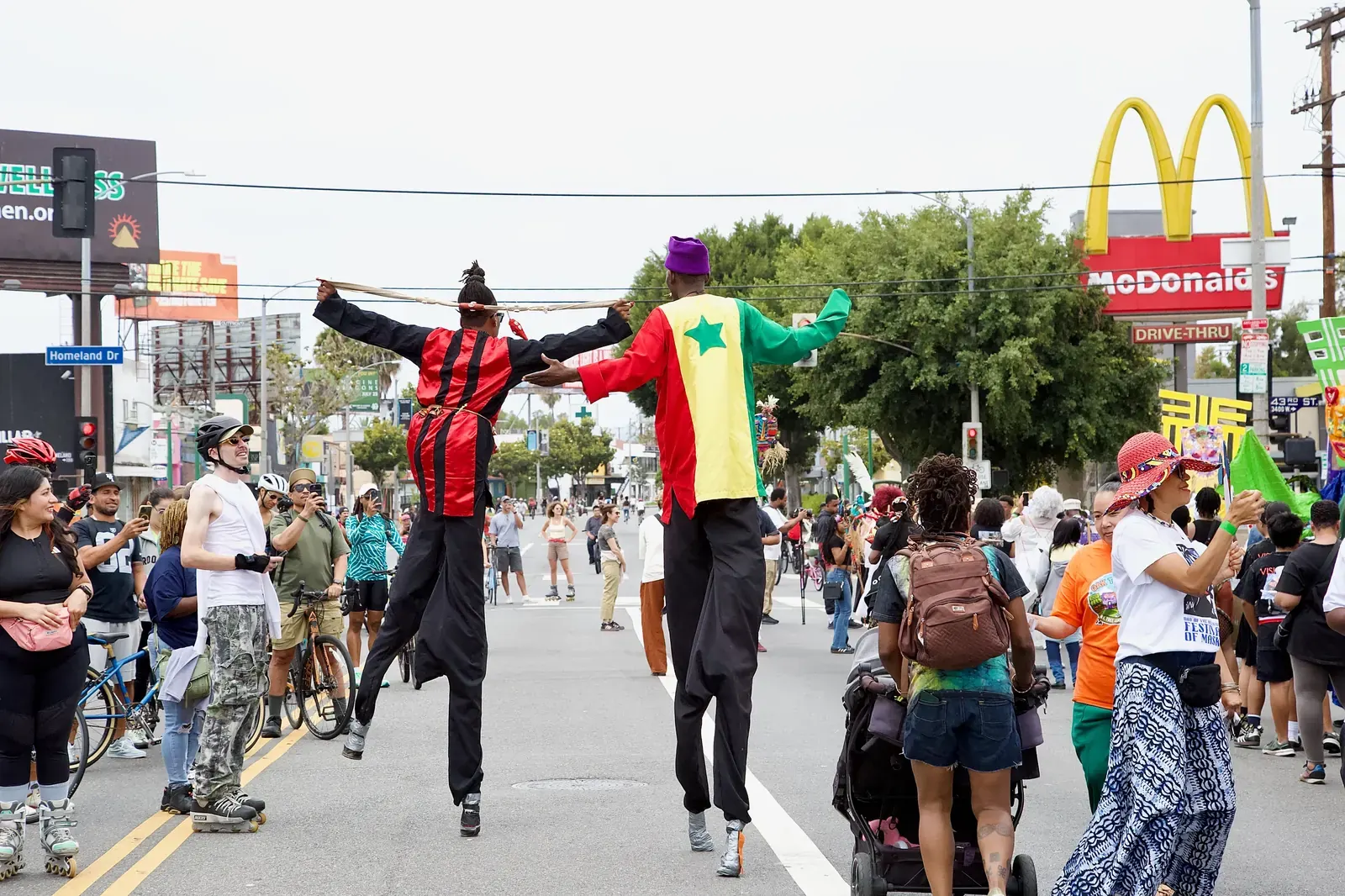 People walking, cycling, and gathering on a closed-off street during the CicLAvia event in Los Angeles.