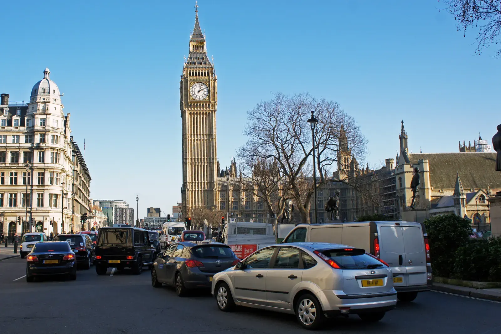 A view of busy London traffic with iconic red buses and black cabs.