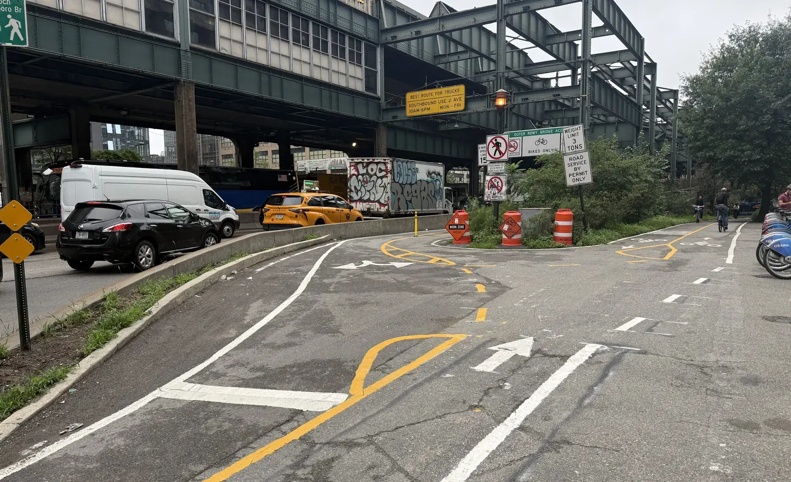 Cyclists riding on the Queensboro Bridge with Manhattan in the background.