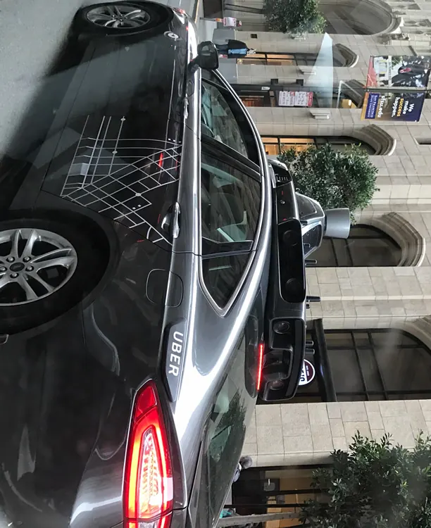 White Waymo robotaxi with roof-mounted LiDAR and sensor array driving on a San Francisco street, illustrating autonomous vehicle technology studied in the IIHS report